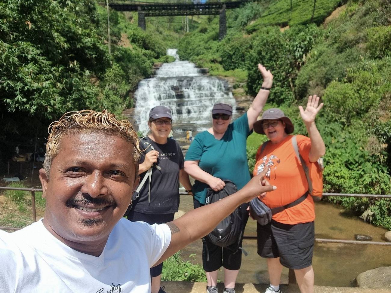 Guide and travellers at a waterfall stop on a Sri Lanka round tour